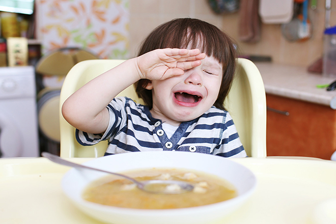 Bé trai nhìn đĩa đồ ăn và khóc