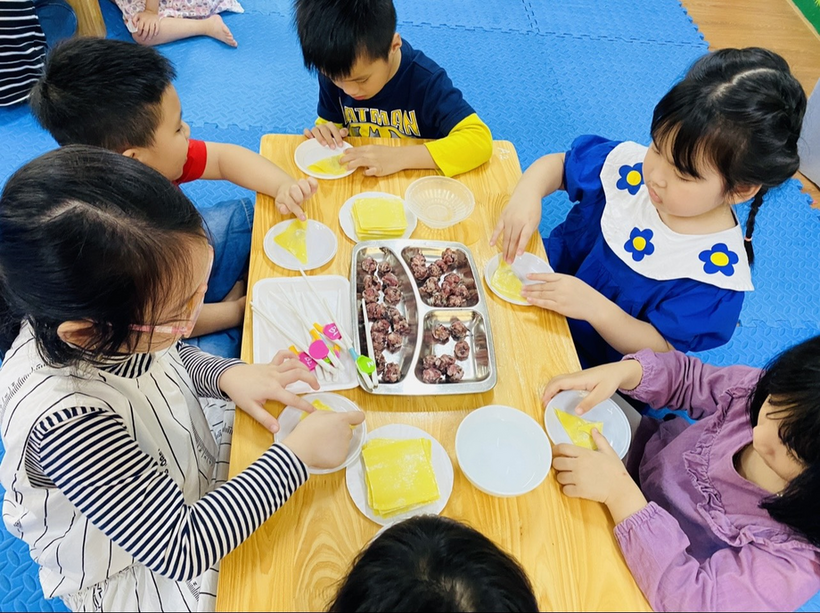 A group of children eating at a table
Description automatically generated with medium confidence