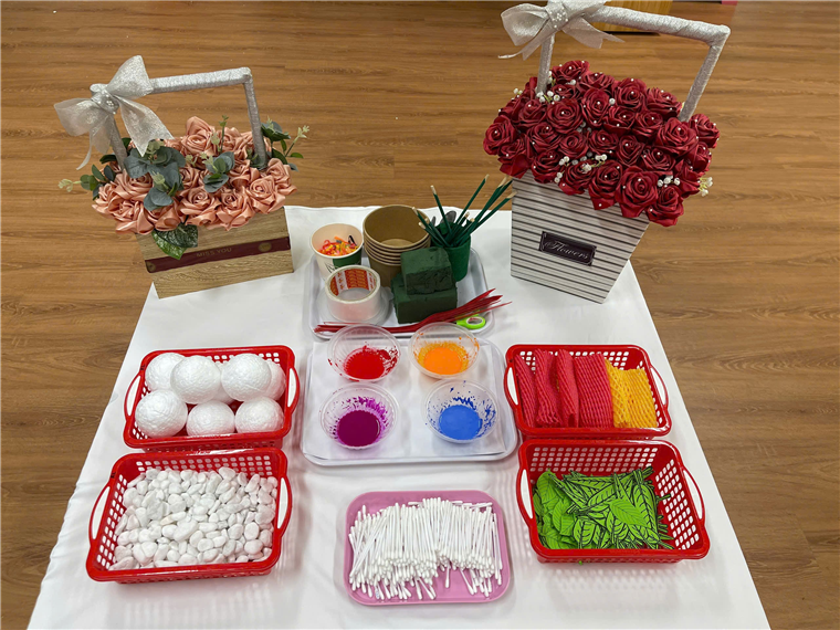 A table with baskets of flowers and baskets of paint

Description automatically generated