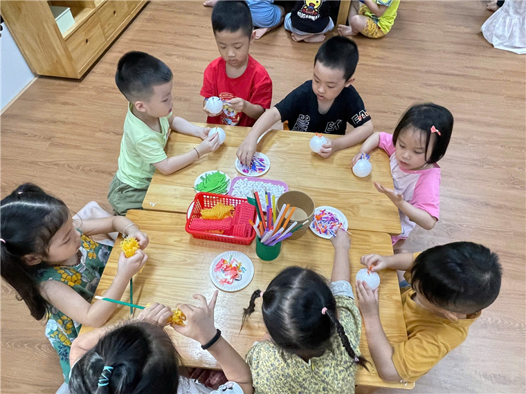 A group of children sitting around a table

Description automatically generated