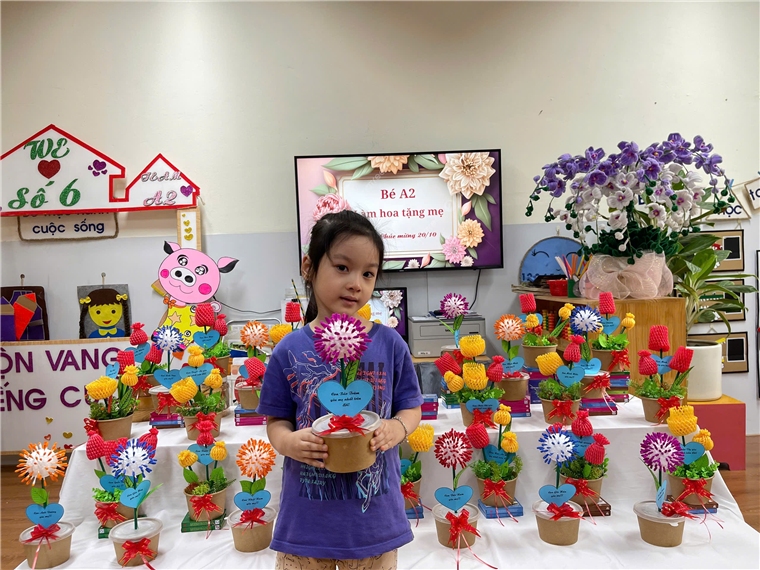 A child holding a pot of flowers

Description automatically generated