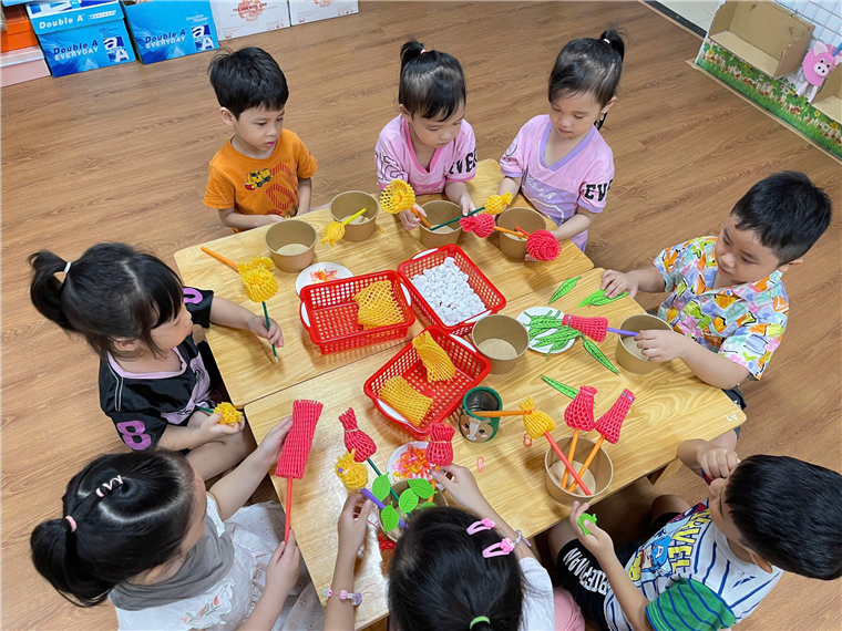 A group of children sitting around a table

Description automatically generated
