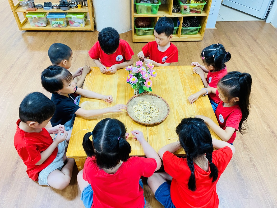 A group of children sitting around a table
Description automatically generated