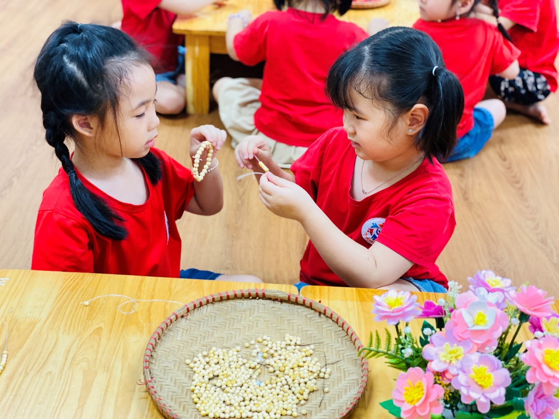 A group of children in red shirts sitting at a table
Description automatically generated