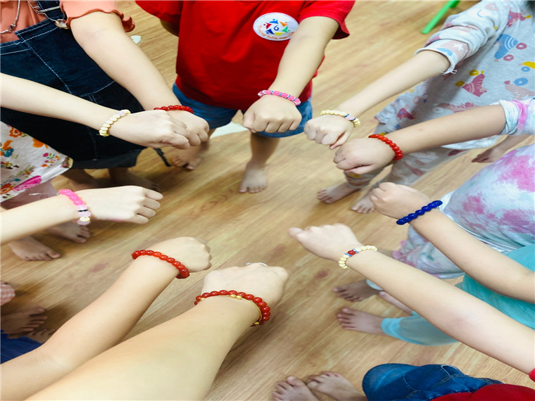 A group of children holding their hands together
Description automatically generated