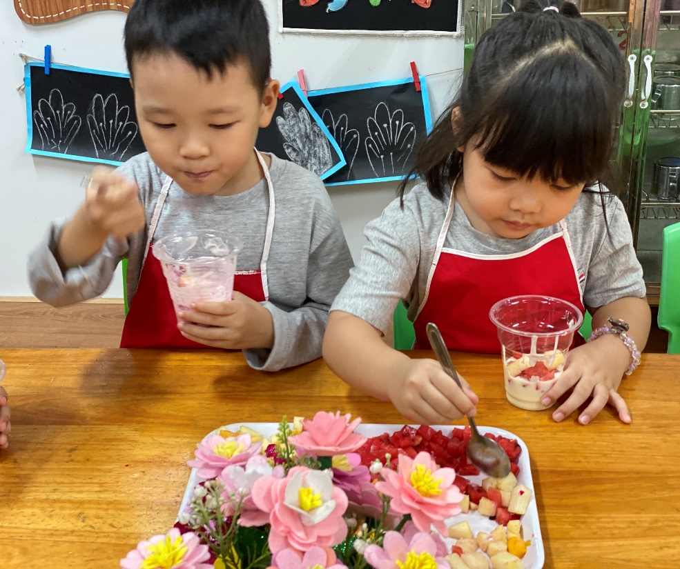 A couple of children eating dessert
Description automatically generated
