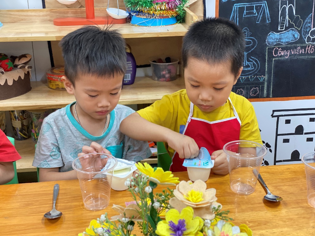 Two young boys sitting at a table
Description automatically generated