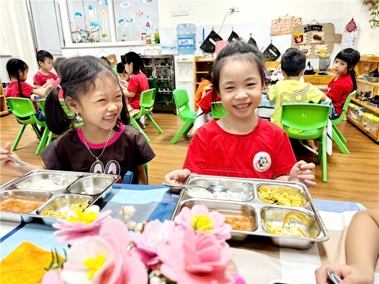 A group of children sitting at a table with food
Description automatically generated