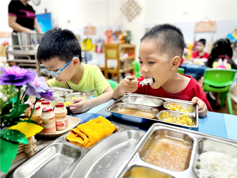 A group of children eating at a table
Description automatically generated