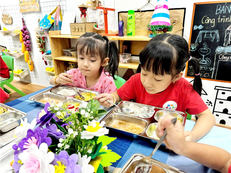 A group of children eating at a table
Description automatically generated