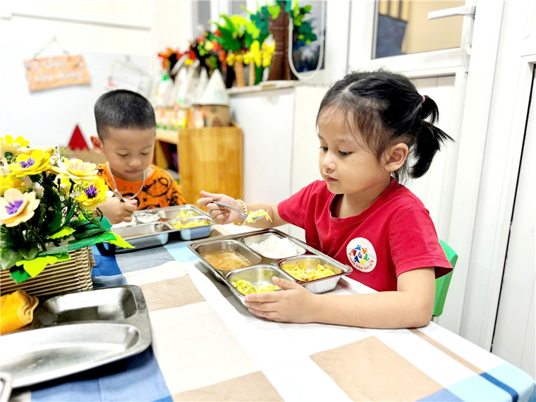 A young children eating at a table
Description automatically generated