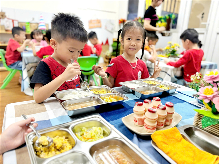 A group of children eating at a table
Description automatically generated