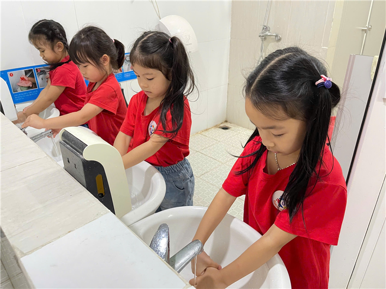 A group of girls washing hands
Description automatically generated