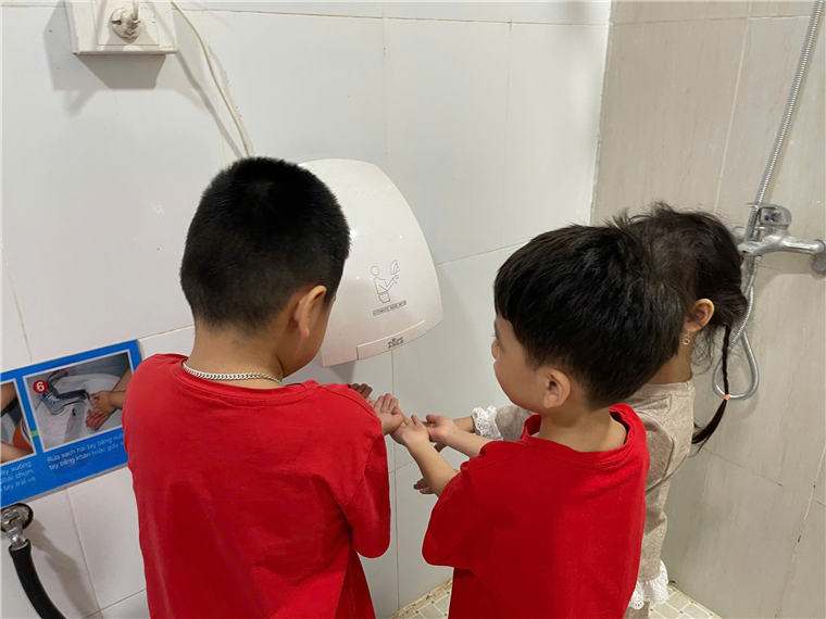 A group of children washing hands
Description automatically generated