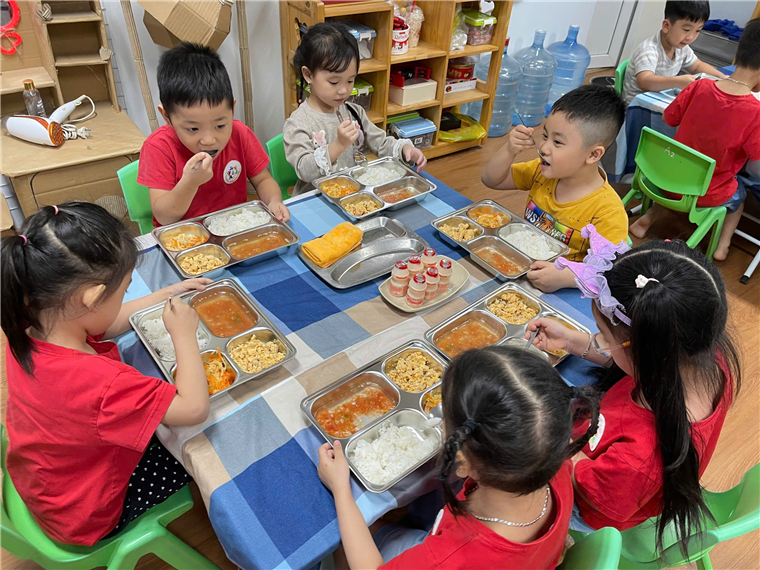 A group of children eating at a table
Description automatically generated