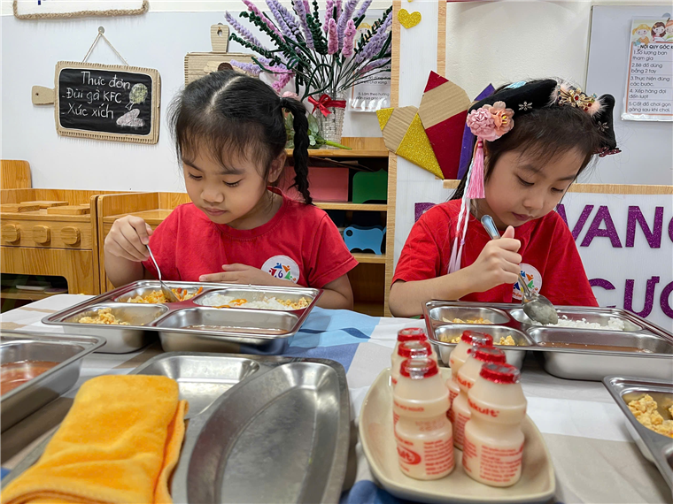 Two girls eating at a table
Description automatically generated