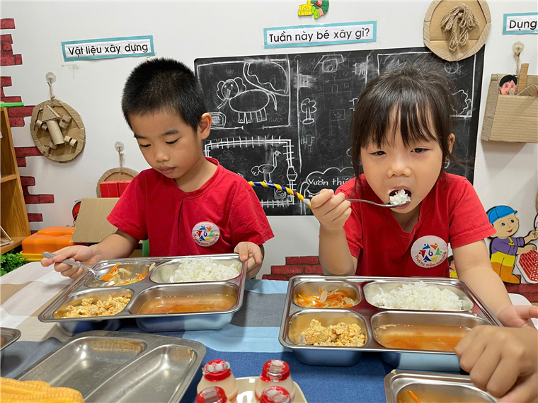 A group of children eating food
Description automatically generated