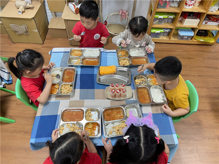 A group of children eating food
Description automatically generated