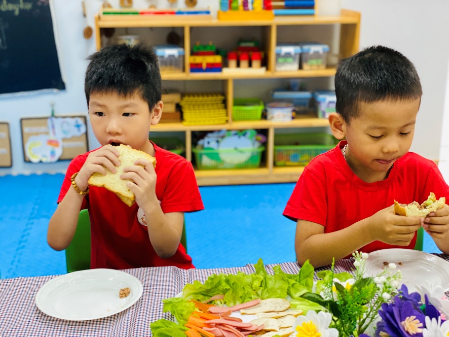 Two boys eating at a table
Description automatically generated