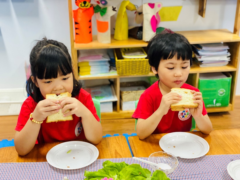 Two children eating at a table
Description automatically generated