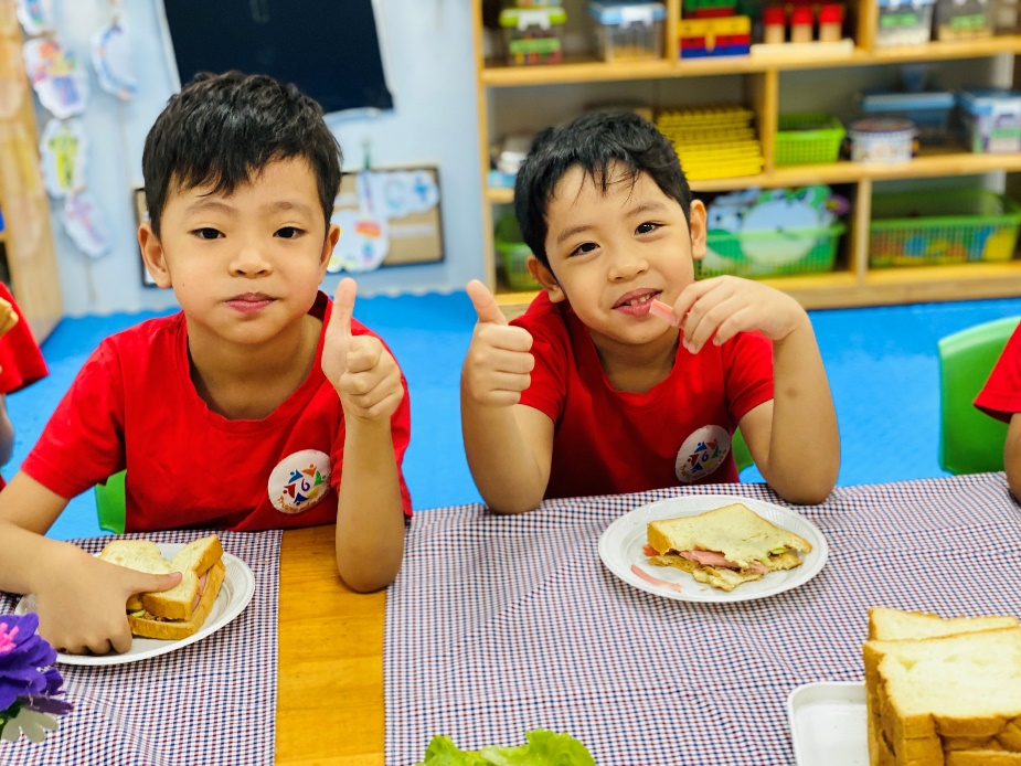 Two boys sitting at a table with plates of food
Description automatically generated