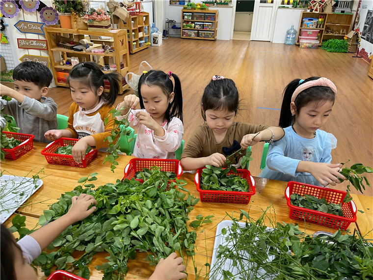 A group of children working at a table
Description automatically generated