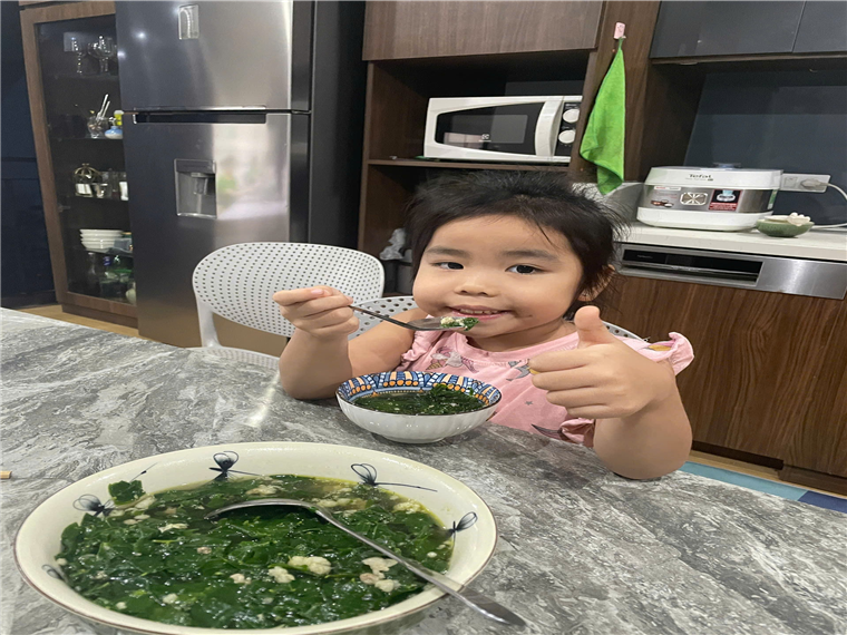 A child eating soup with a fork
Description automatically generated