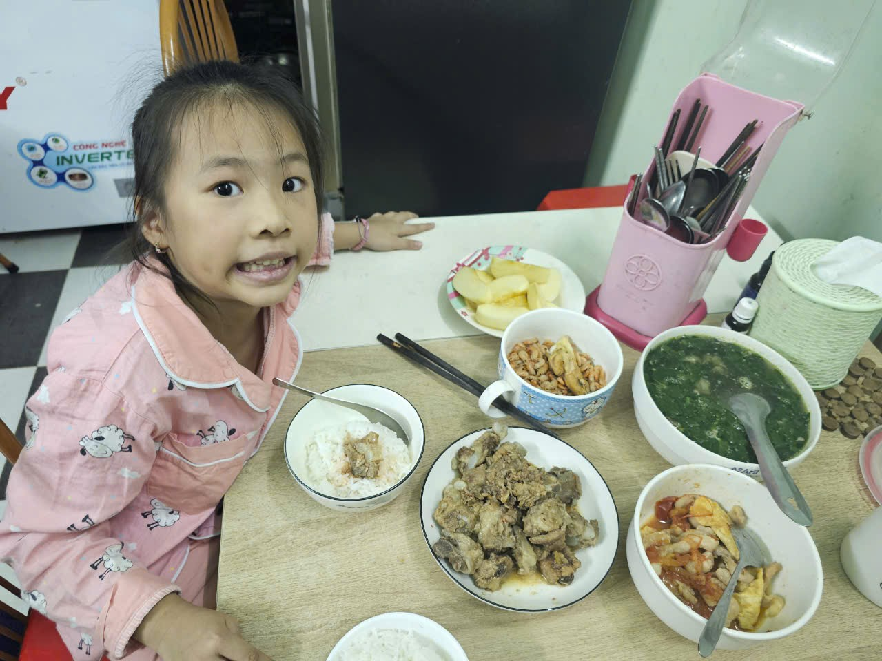 A child sitting at a table with food
Description automatically generated