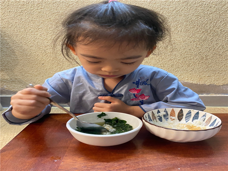 A child eating food in a bowl
Description automatically generated