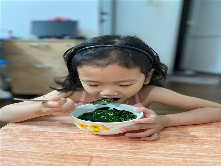 A child eating food from a bowl
Description automatically generated