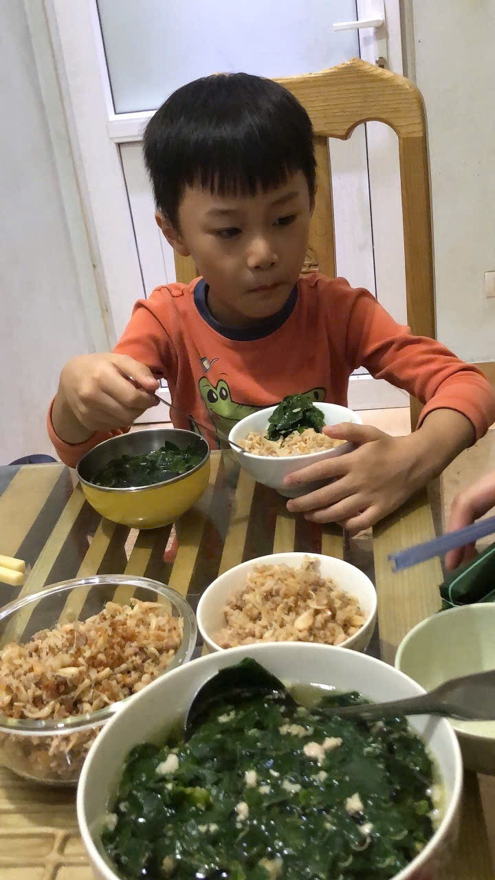 A child eating at a table
Description automatically generated