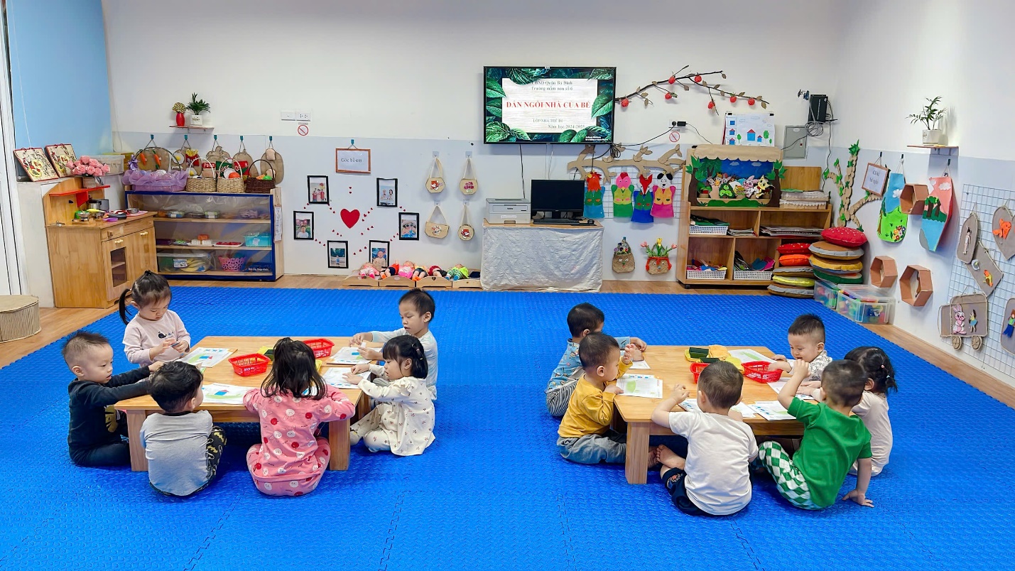 A group of children sitting on the floor in a classroom
Description automatically generated