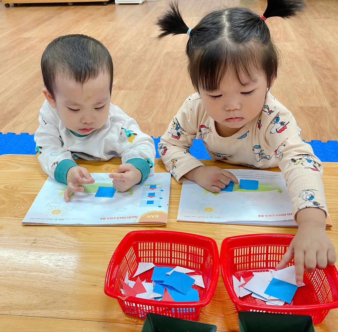 A couple of children playing with paper
Description automatically generated