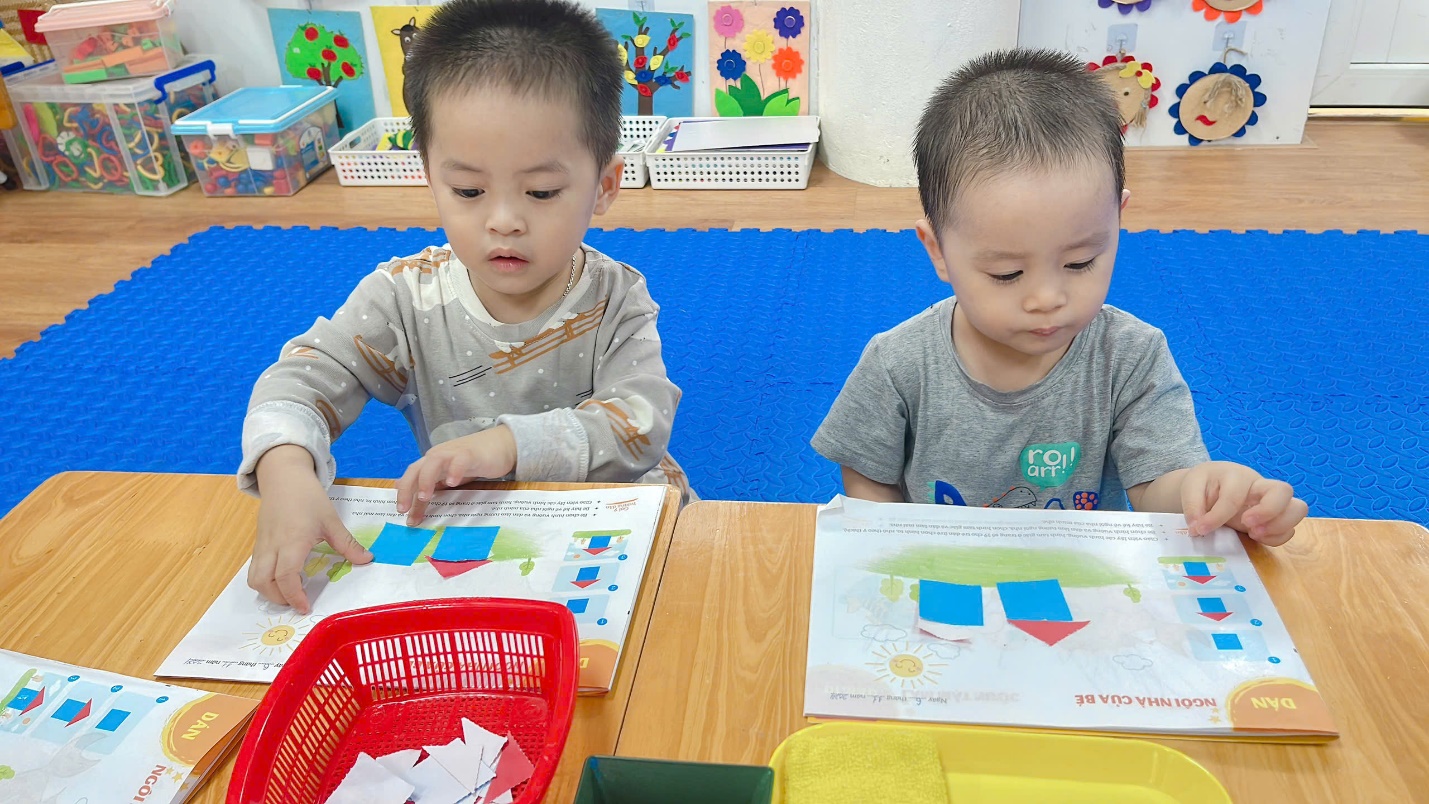 A pair of young boys sitting at a table
Description automatically generated