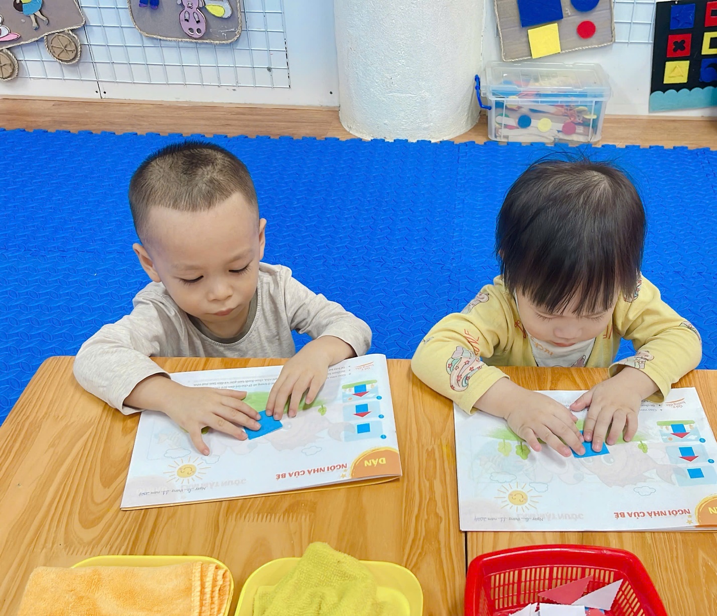 A group of children sitting at a table with paper
Description automatically generated