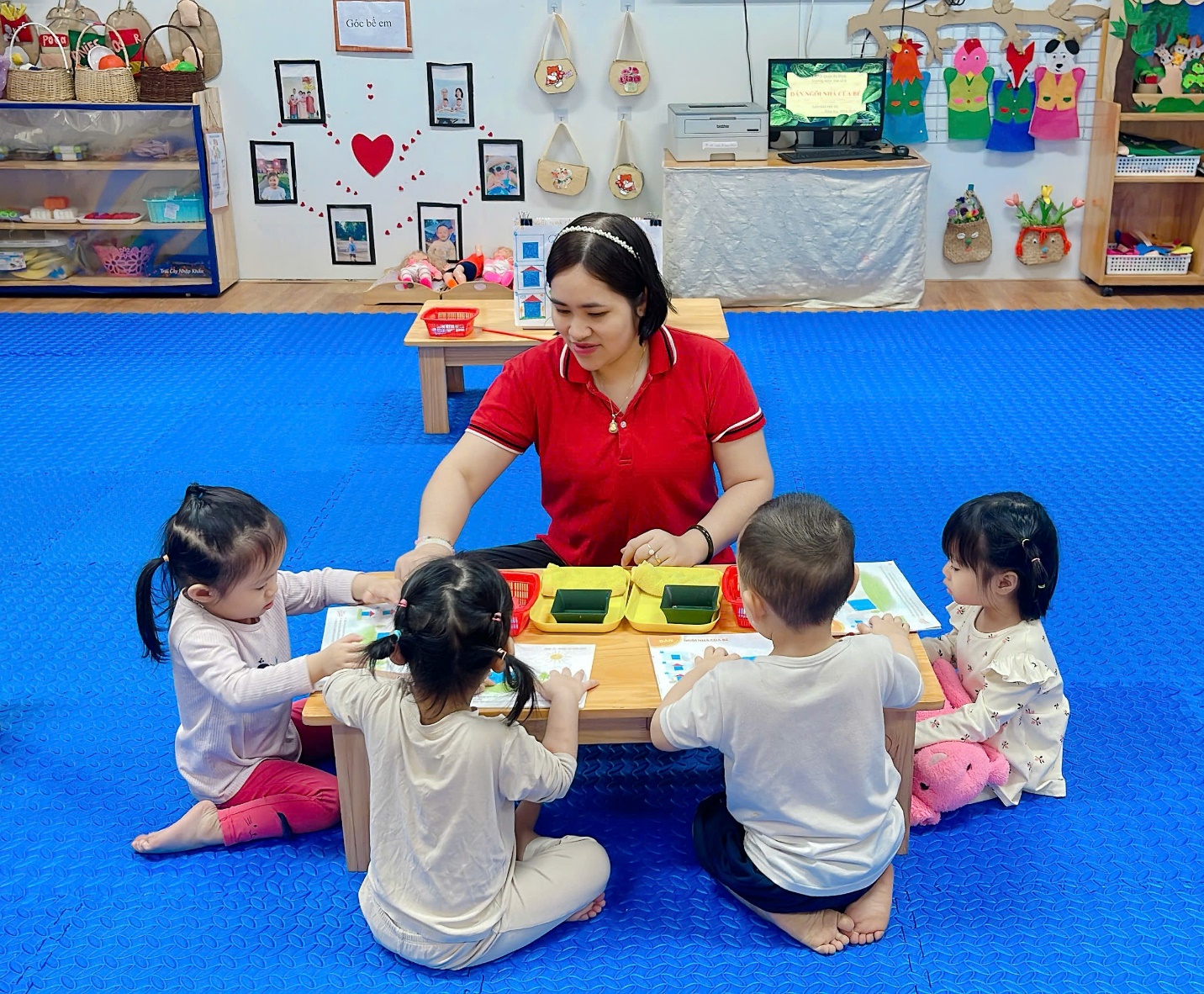 A person and children sitting around a table
Description automatically generated