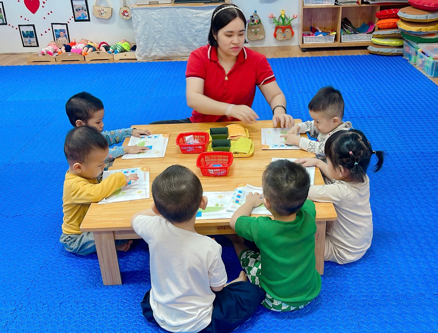 A group of children sitting around a table
Description automatically generated