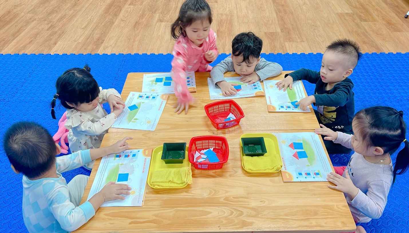 A group of children sitting around a table
Description automatically generated