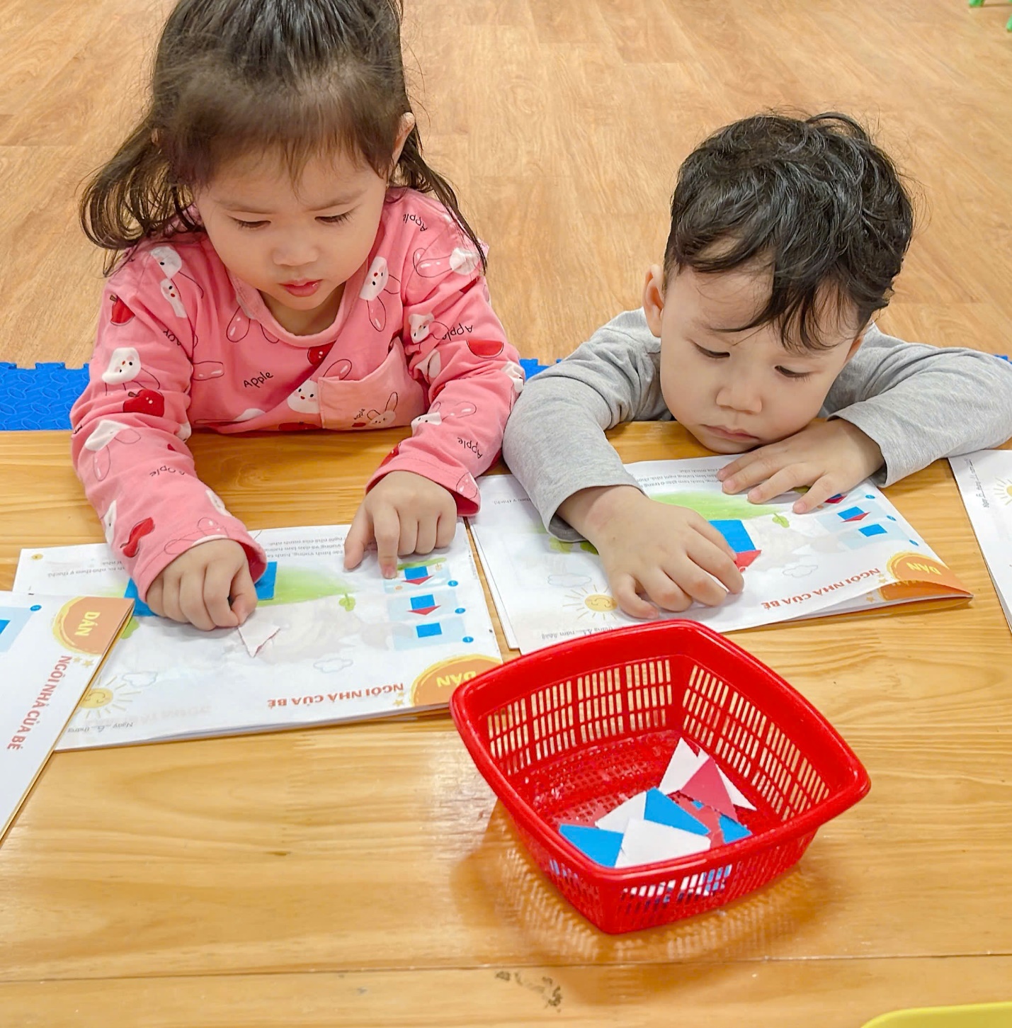 A two children sitting on a table
Description automatically generated