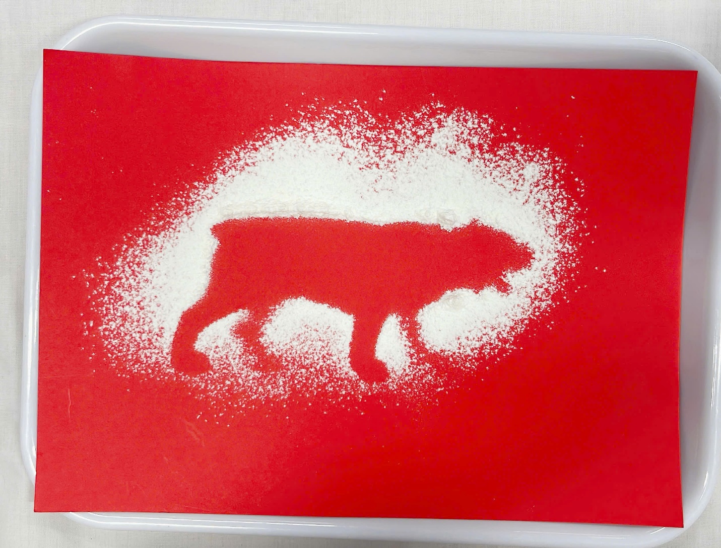 A red and white tray with a red background with a silhouette of a wolf

Description automatically generated