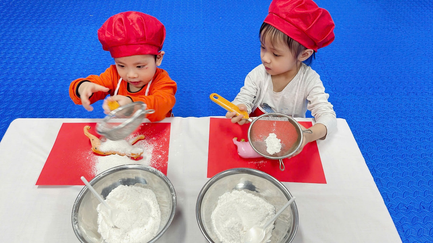 A couple of children in chef hats cooking

Description automatically generated