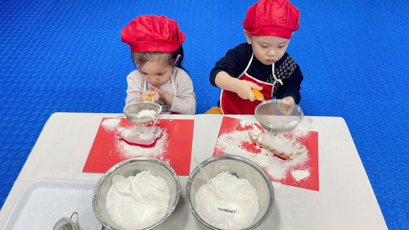 A couple of kids making food

Description automatically generated