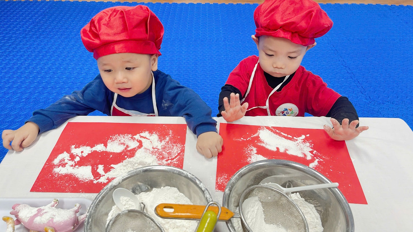 Two young boys wearing chef hats and aprons

Description automatically generated