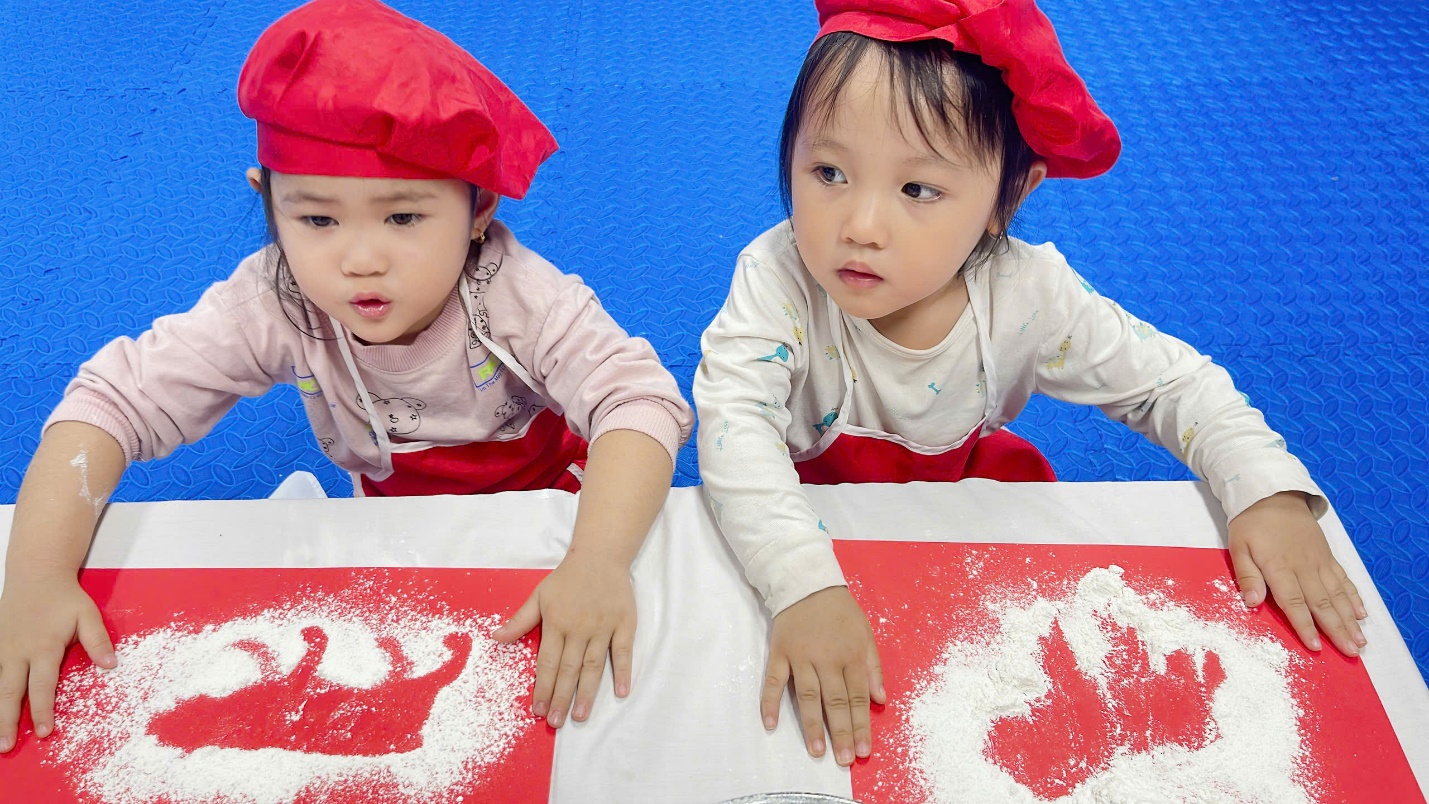 Two children wearing red hats and white shirts

Description automatically generated