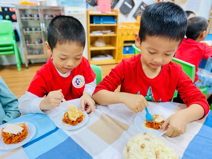 A pair of young boys eating at a table

Description automatically generated