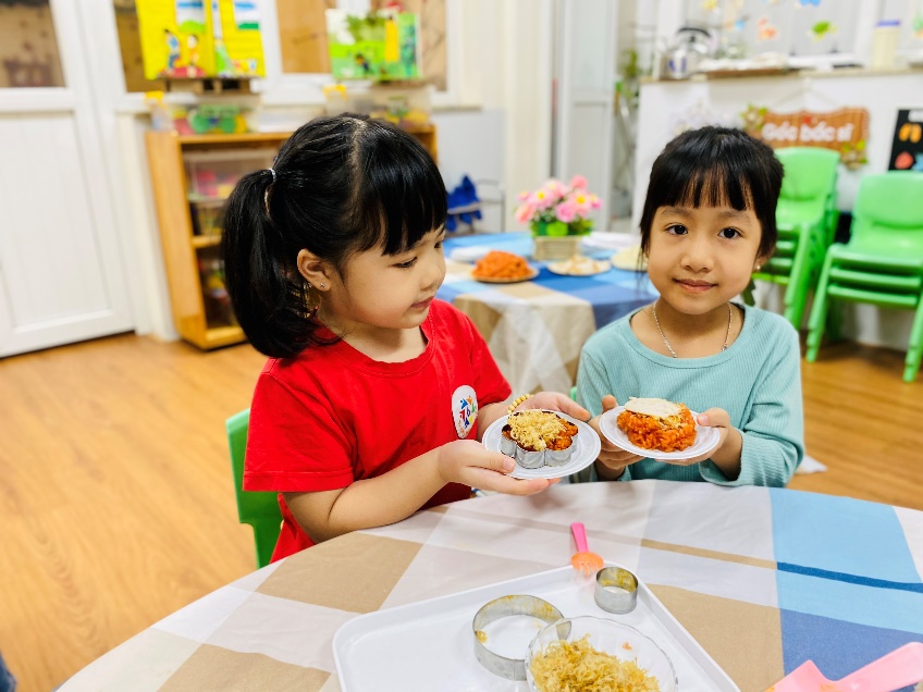 A couple of girls holding plates of food

Description automatically generated