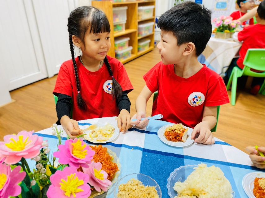 A child and child sitting at a table with plates of food

Description automatically generated