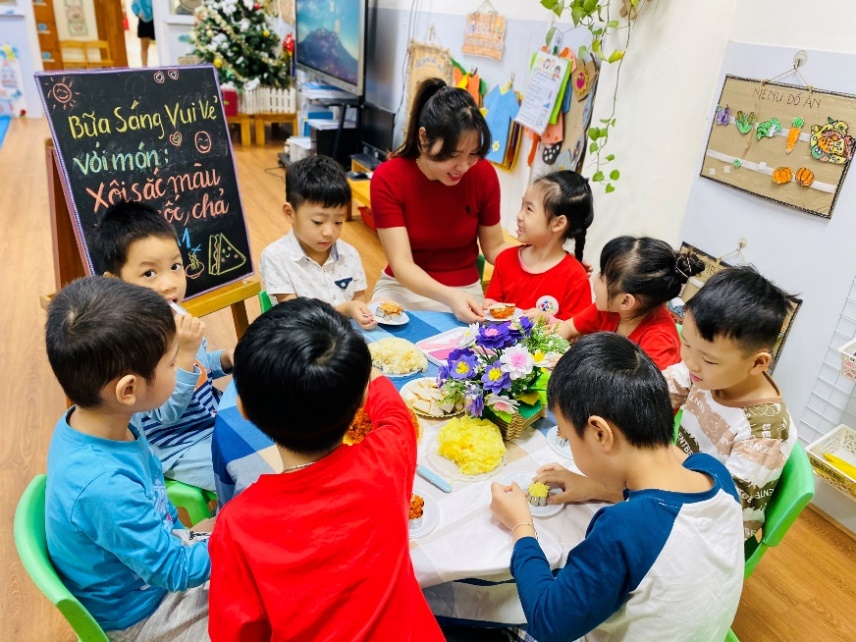A group of children sitting around a table

Description automatically generated