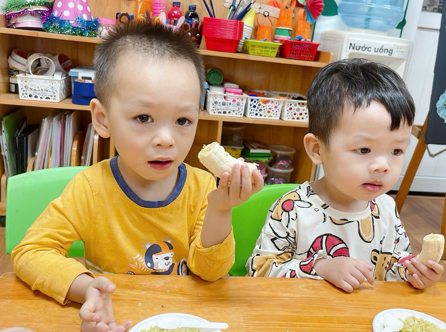 Two young boys sitting at a table eating

Description automatically generated