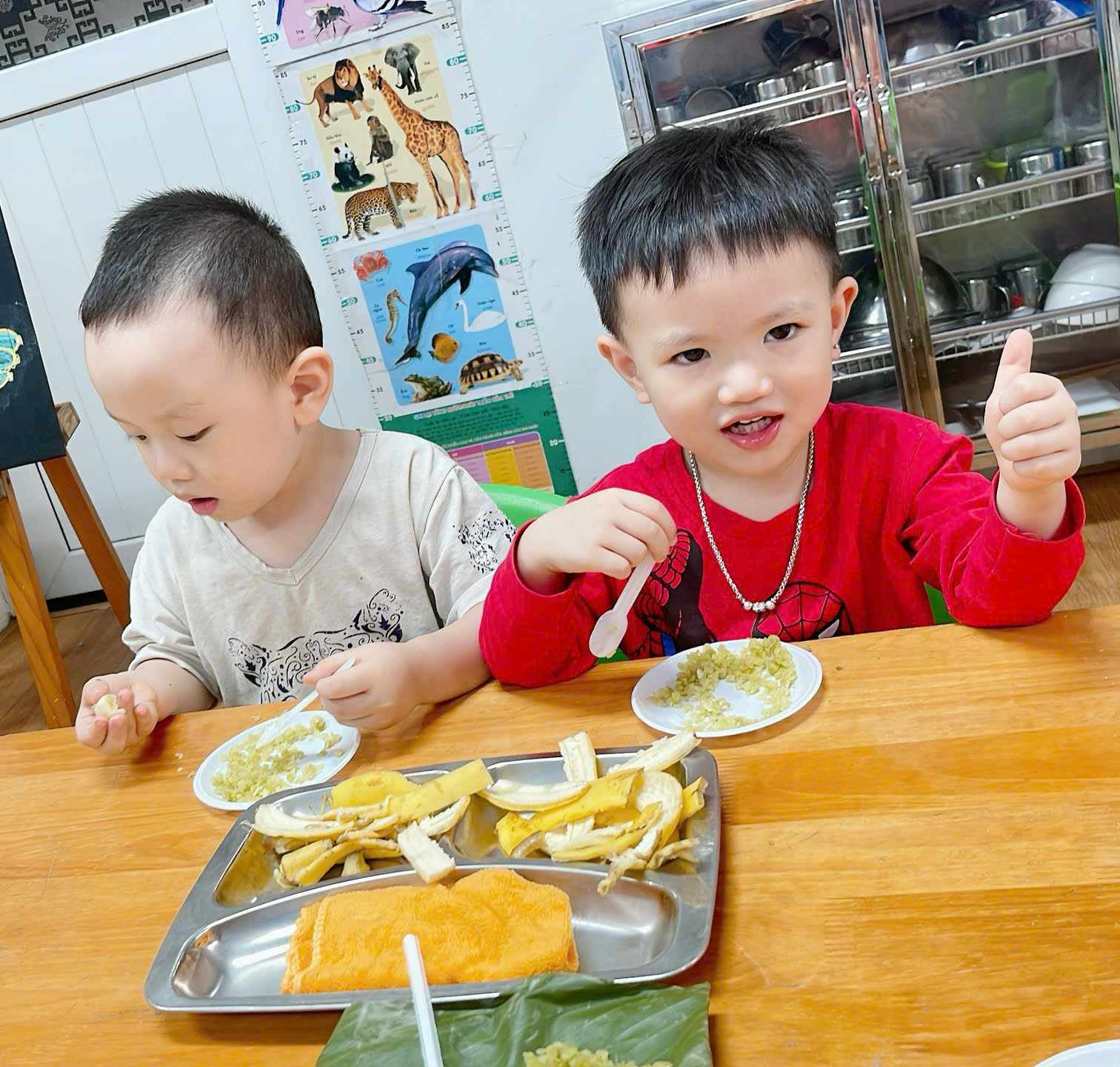 Two young boys sitting at a table eating

Description automatically generated